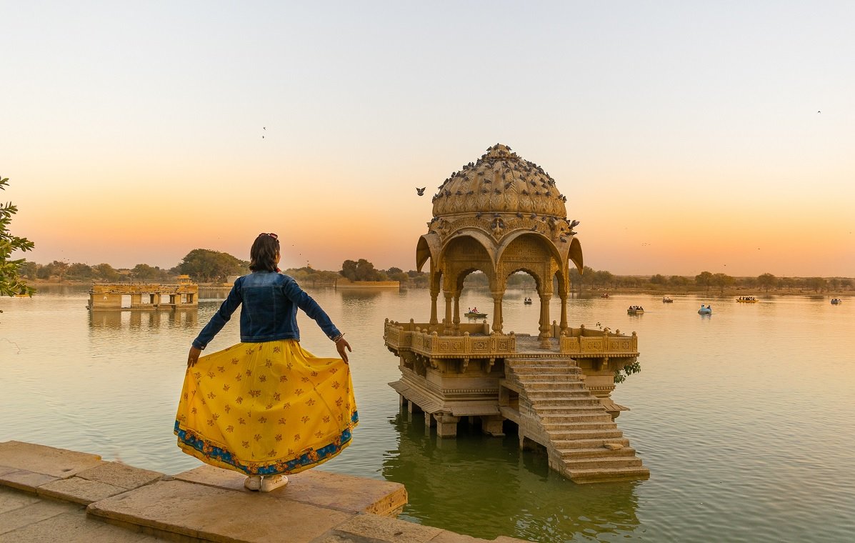 Lago Gadisar en Jaisalmer al amanecer con templos reflejados en el agua, India