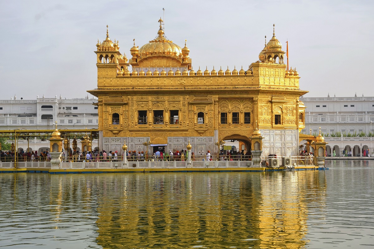 Templo de Oro de Amritsar iluminado y reflejado en el agua sagrada, Punjab, India